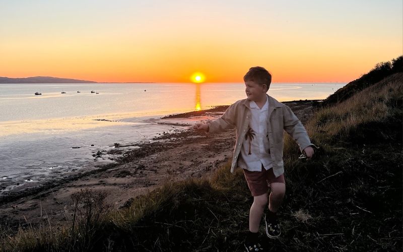 Wirral Country Park boy dancing at sunset.