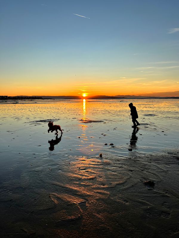 Kid and dog running on Hoylake Beach. Kid and dog running on Hoylake Beach.