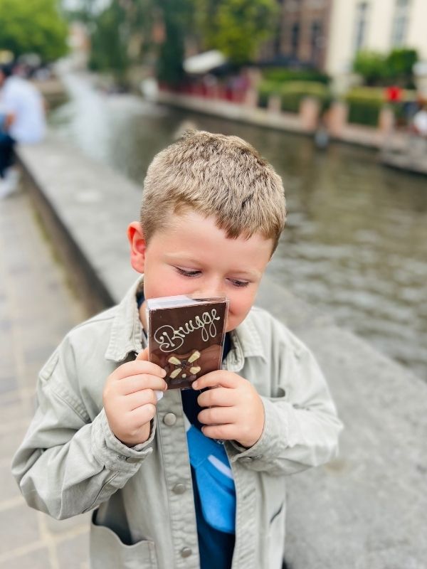 Little boy holding handmade chocolate in Bruges.