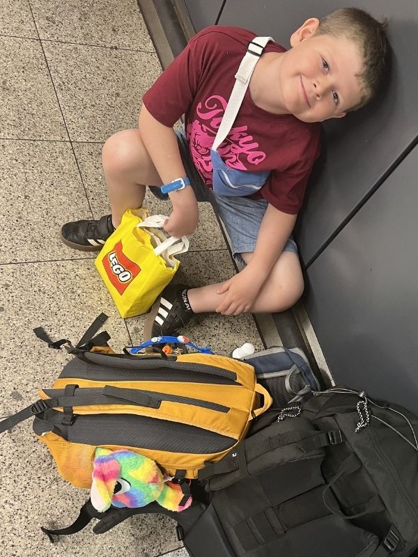 Little boy on train station floor in Amsterdam. One of our favourite memories from interrailing with kids.